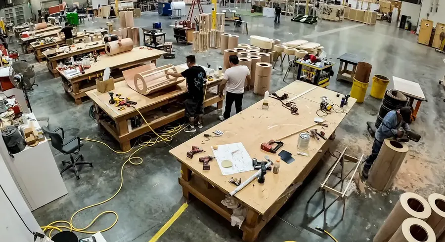 Holzwerkstatt mit gebogenen Bauteilen und Werkbänken